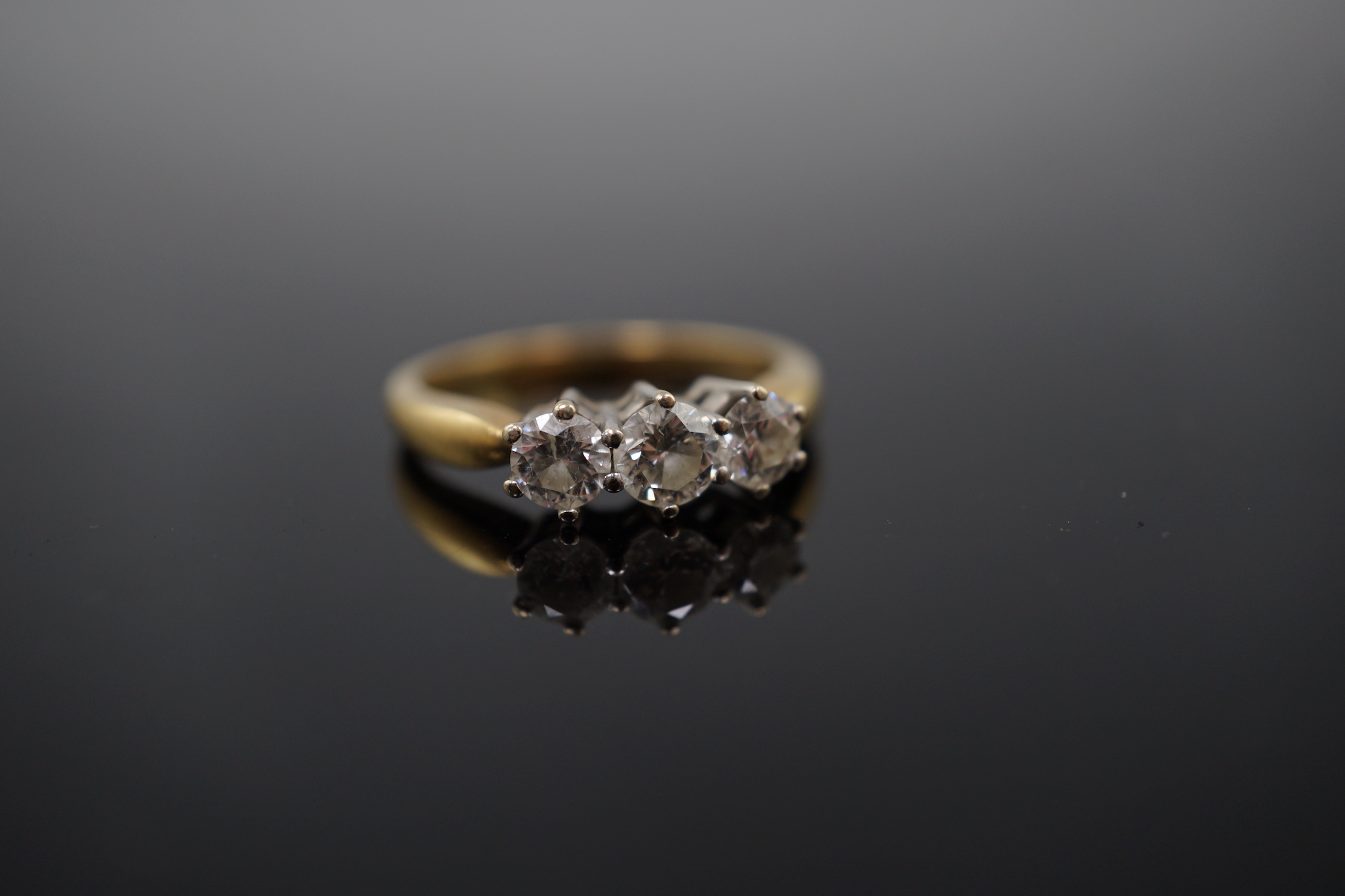 A modern 18ct gold and three stone diamond set ring